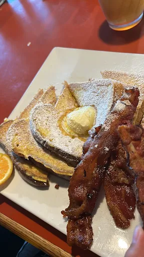 Powdered sugar French toast with butter and thick-cut bacon